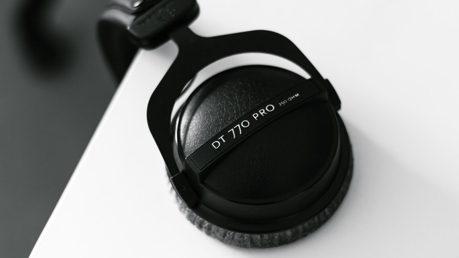Overhead view of headphones hanging from the edge of a desk