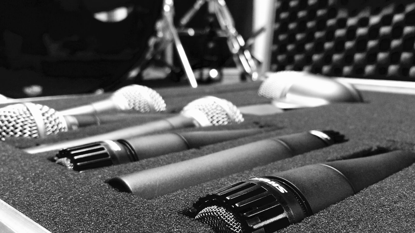 Several dynamic microphones lying in a foam-lined flight case